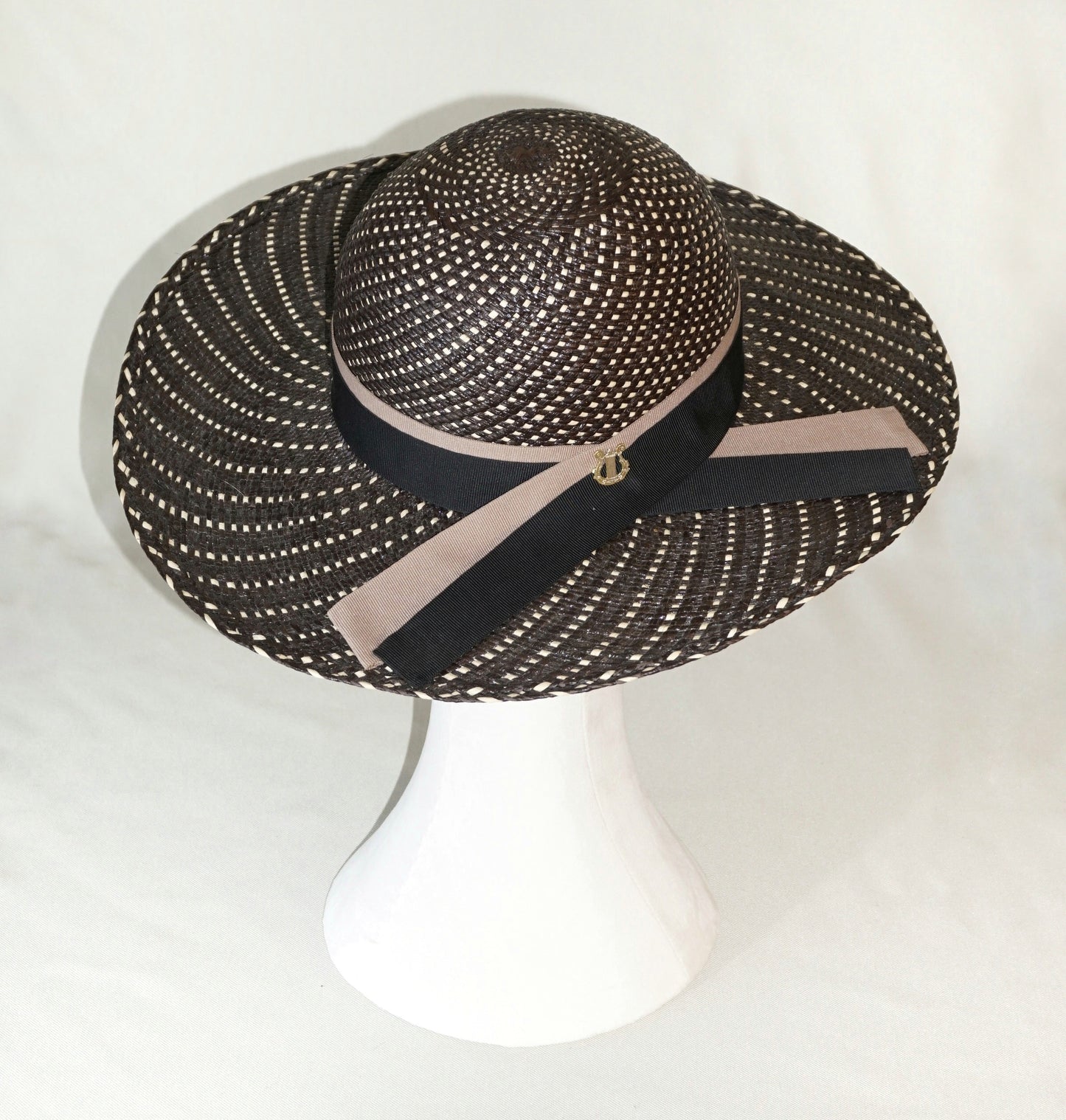 Black and ivory Panama hat with black and nude blush ribbons and gold lyre,  three-quarter  right back view by Anna Xaniotaki