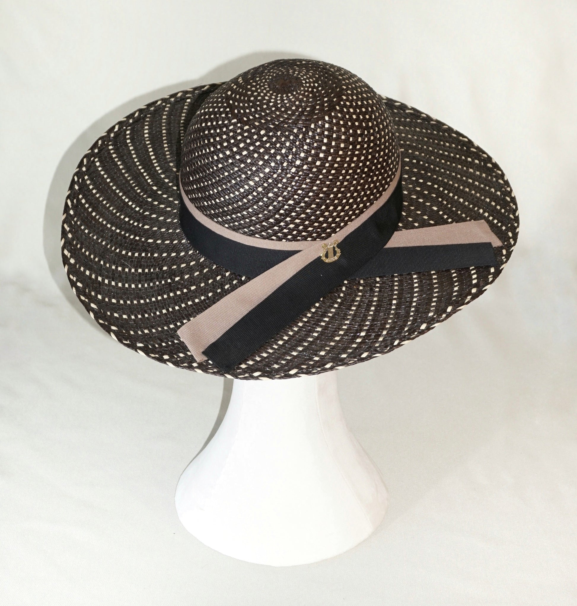 Black and ivory Panama hat with black and nude blush ribbons and gold lyre,  three-quarter  right back view by Anna Xaniotaki