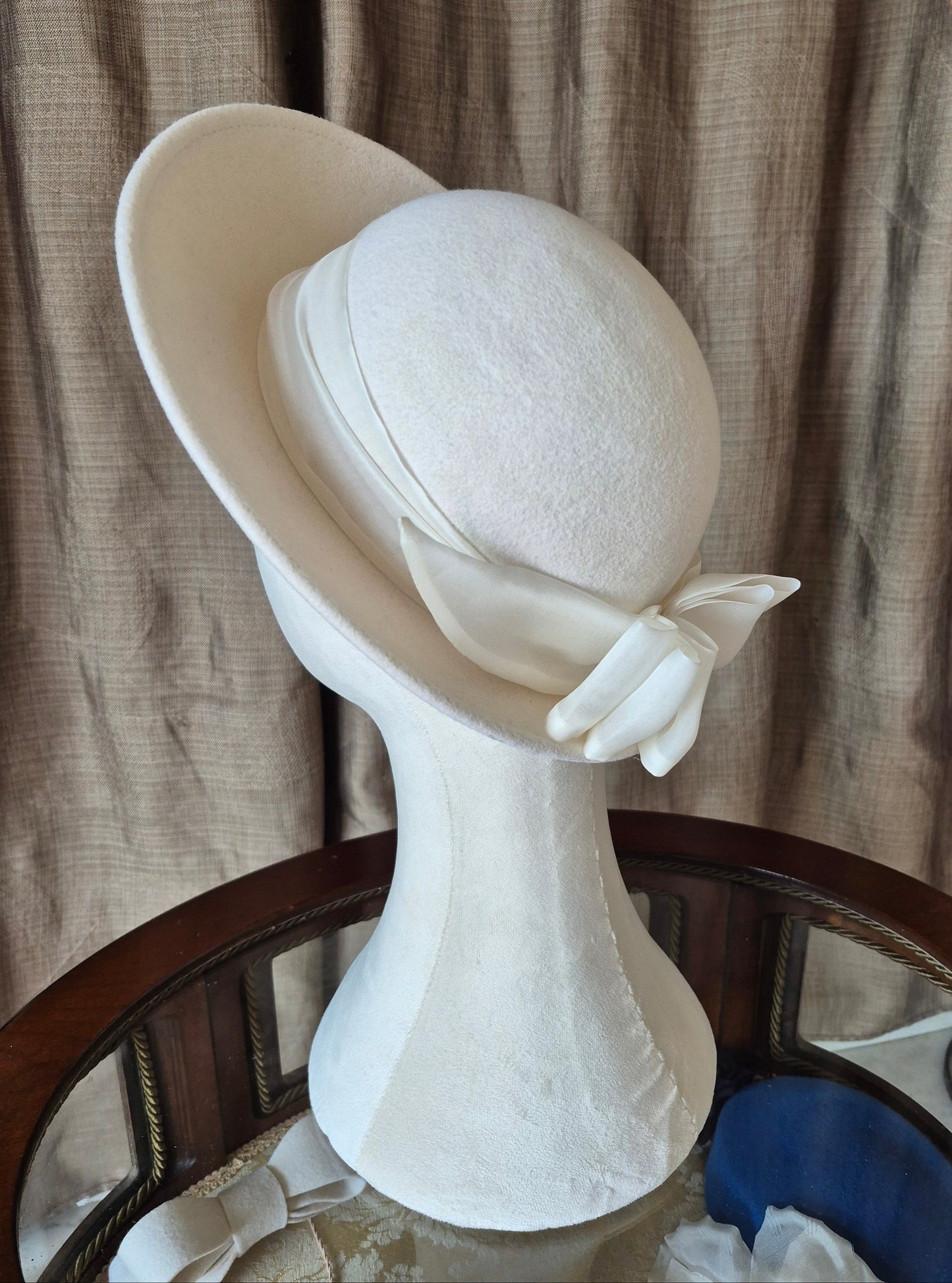Ivory felt halo hat with silk organza bow by Anna Xaniotaki, left side view by Anna Xaniotaki