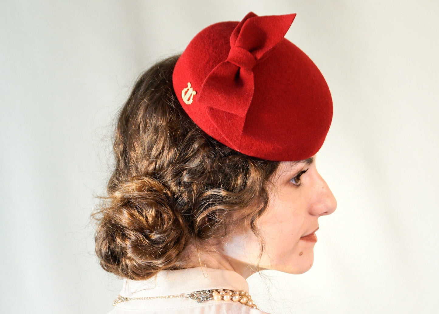 Erato Ode red felt pillbox hat with handmade felt bow and 14ct gold-plated silver lyre by Anna Xaniotaki - right side view