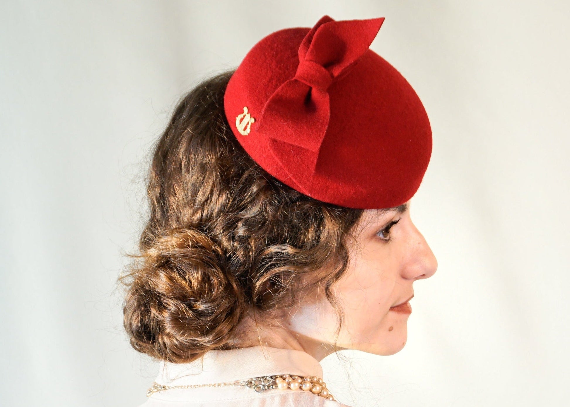 Erato Ode red felt pillbox hat with handmade felt bow and 14ct gold-plated silver lyre by Anna Xaniotaki - right side view