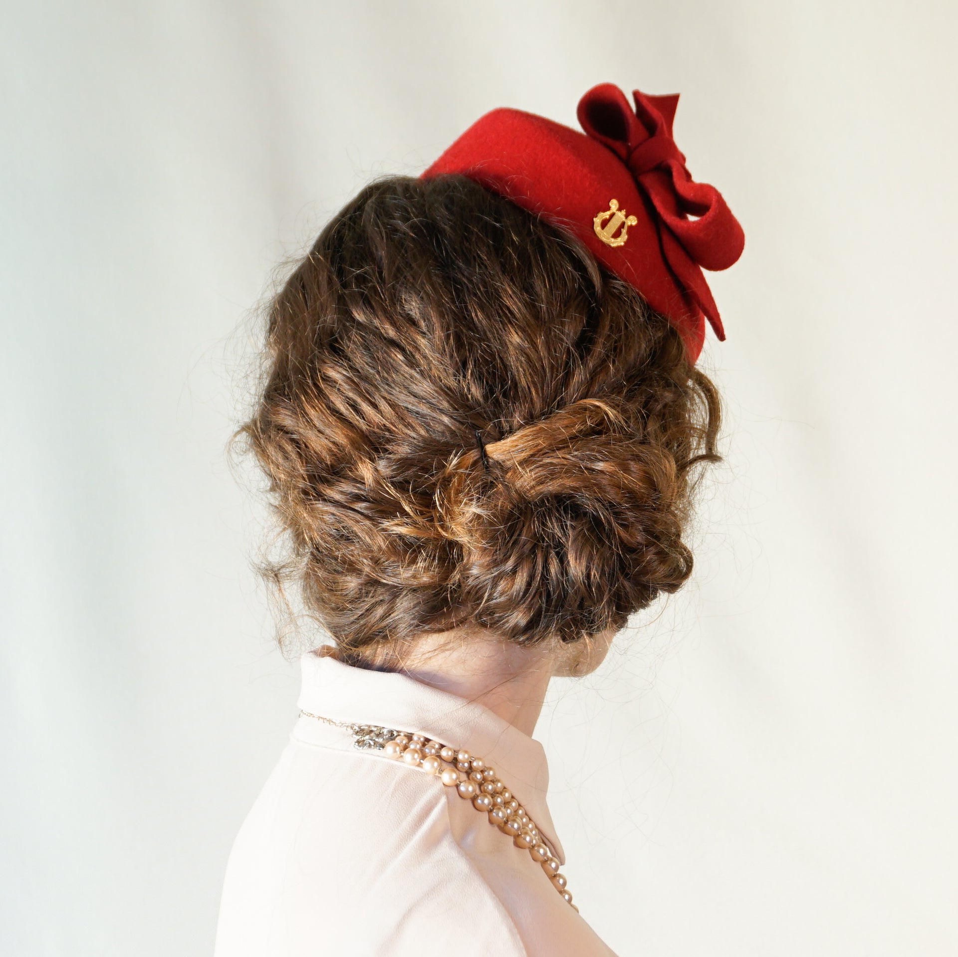 Erato Ode red felt pillbox hat with handmade felt bow and 14ct gold-plated silver lyre by Anna Xaniotaki - back angle view