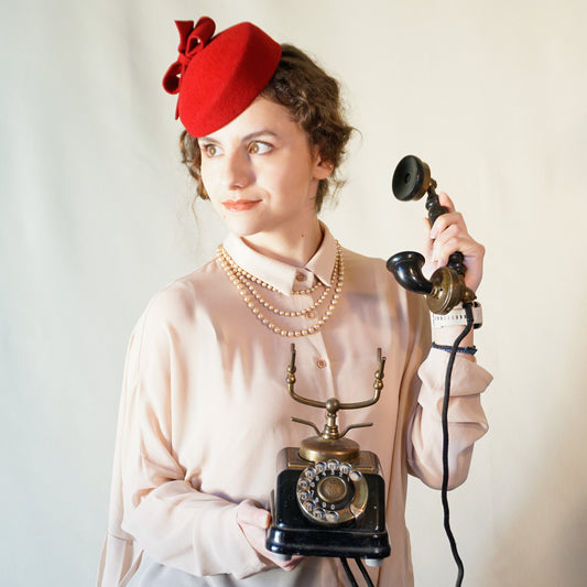Erato Ode red felt pillbox hat with handmade felt bow and 14ct gold-plated silver lyre by Anna Xaniotaki - front left three-quarter view