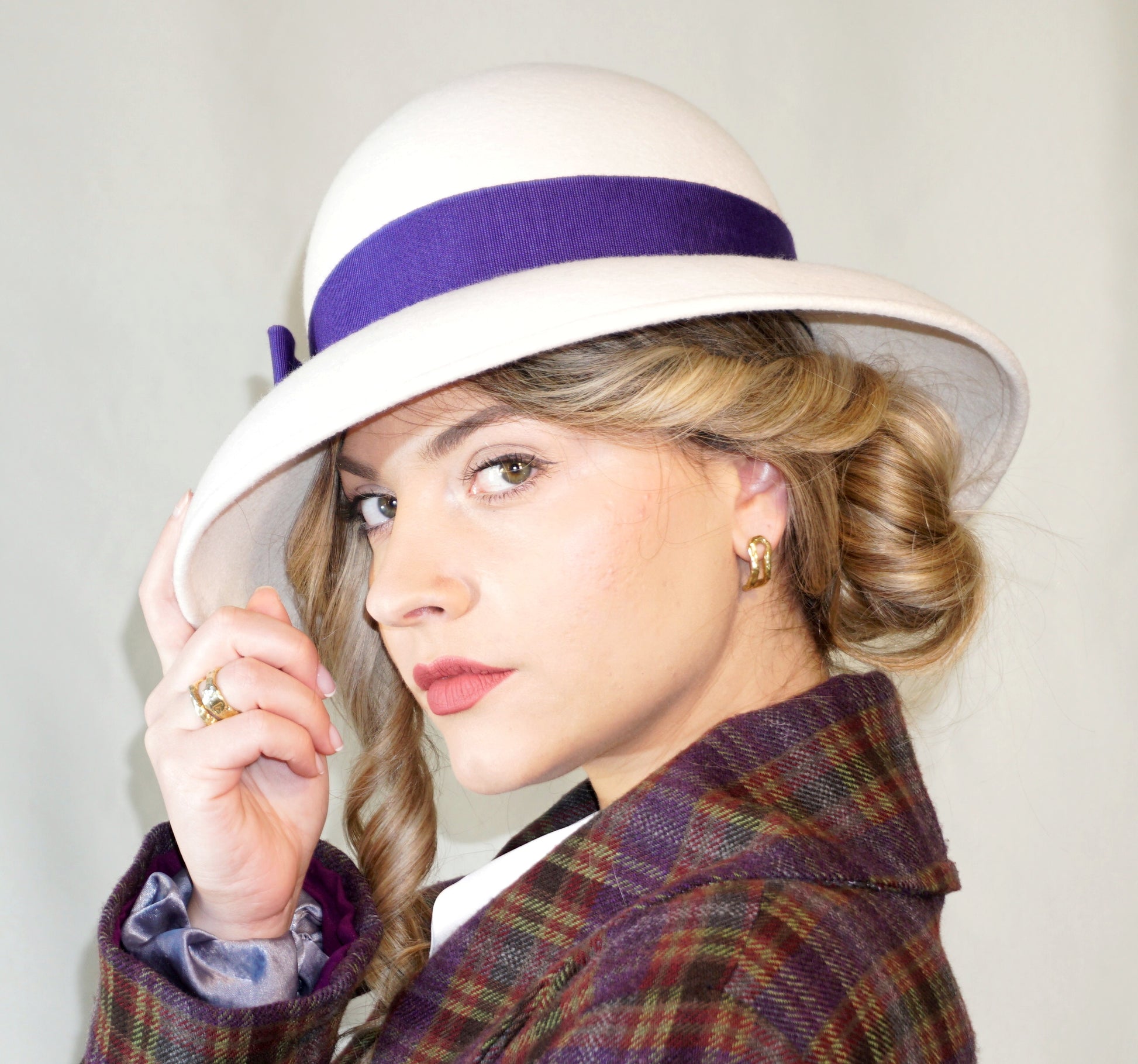 Blanche Élégance white felt hat with purple grosgrain bow and golden lyre by Anna Xaniotaki, left side view