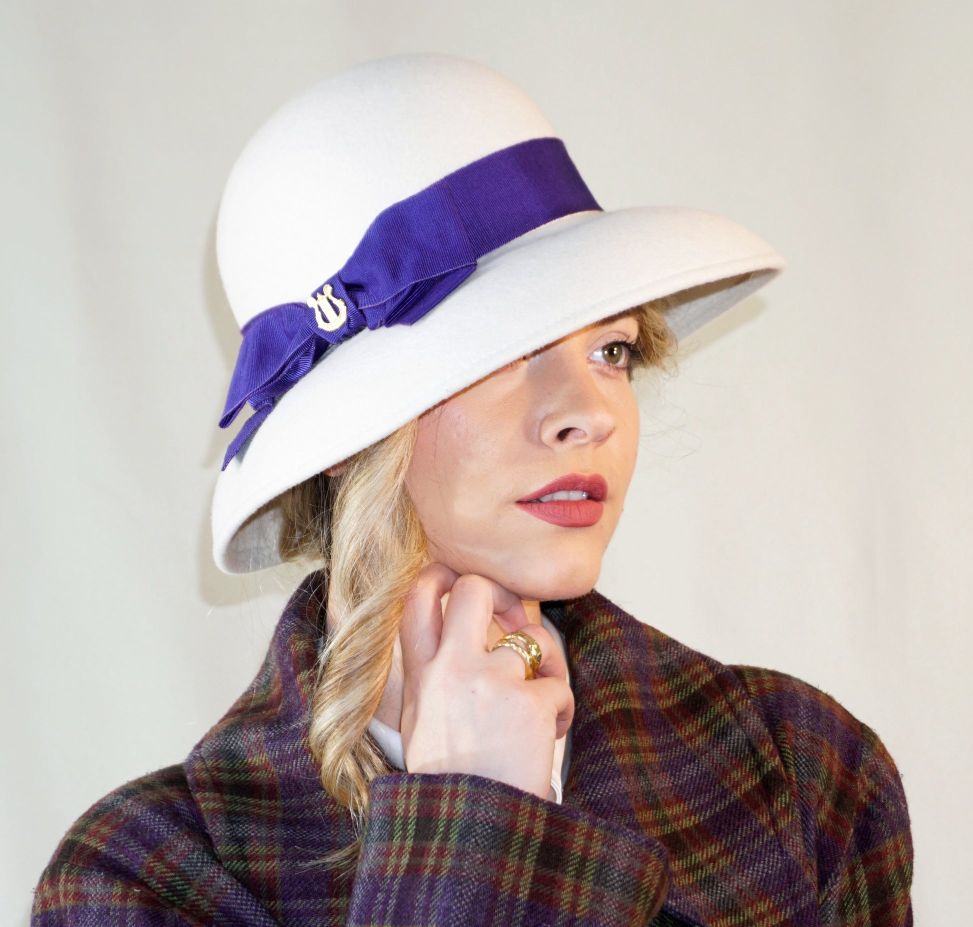 Blanche Élégance white felt hat with purple grosgrain bow and golden lyre by Anna Xaniotaki, right three-quarter view