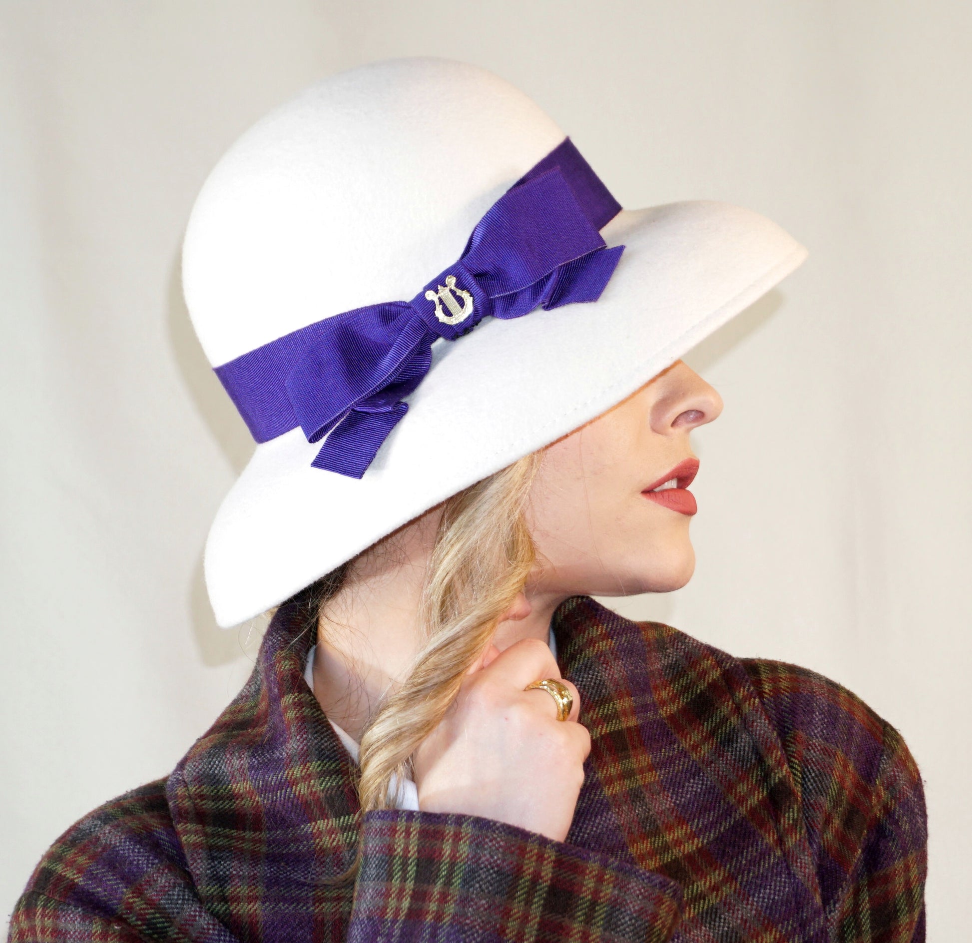 Blanche Élégance white felt hat with purple grosgrain bow and golden lyre by Anna Xaniotaki, right side view
