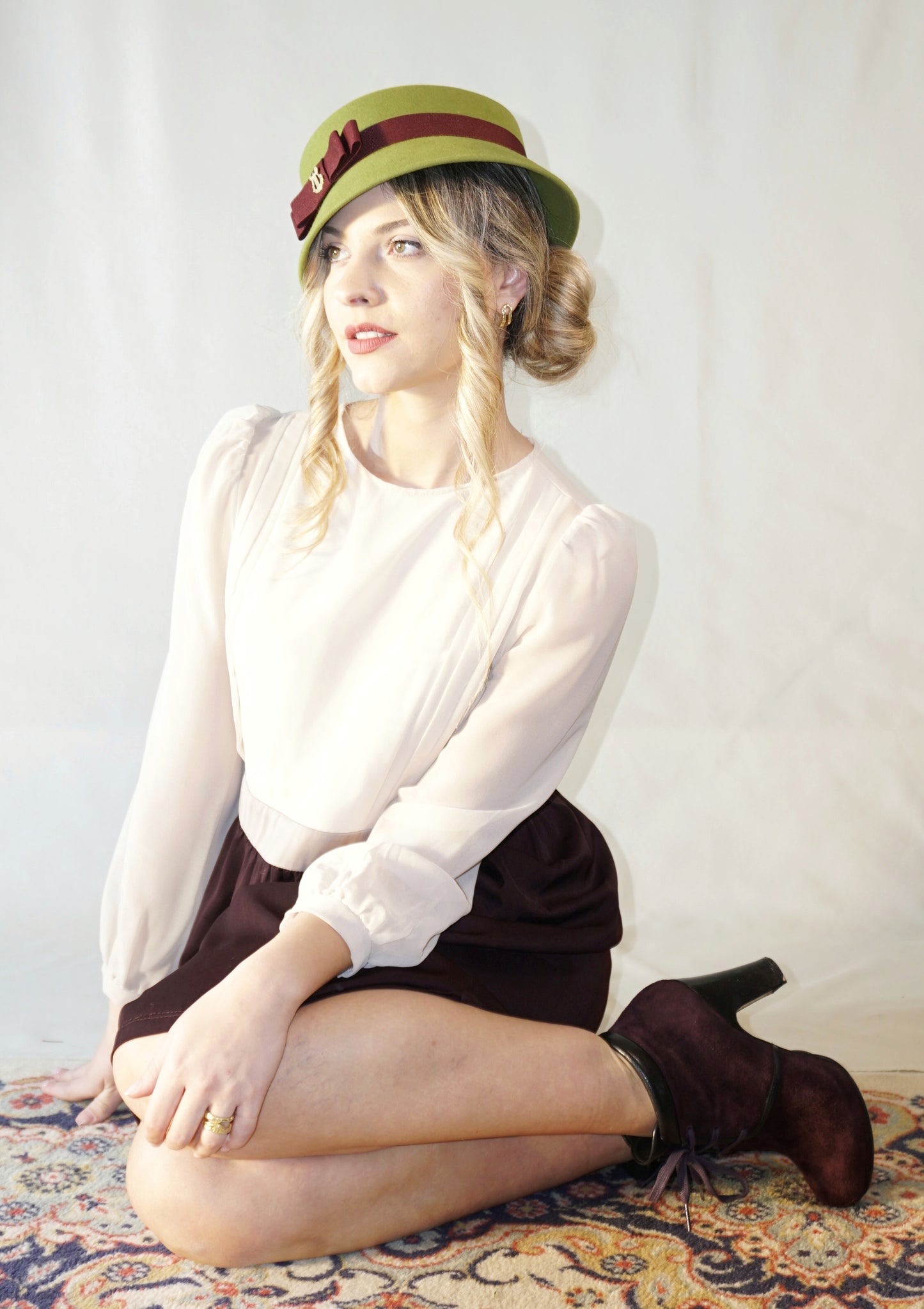 Aristocratic Melody lime pillbox felt hat with double burgundy bow and 14ct gold-plated silver lyre by Anna Xaniotaki - front angle view