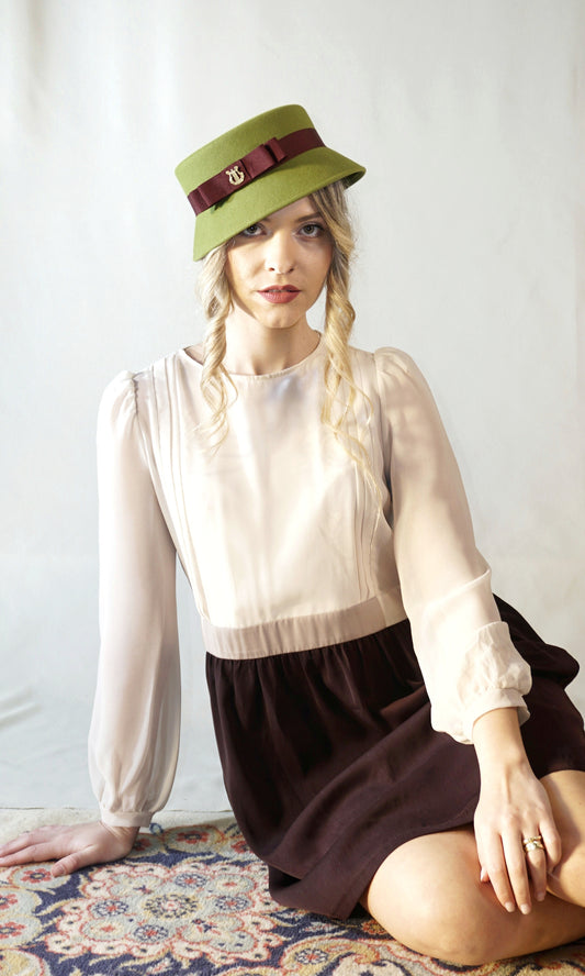 Aristocratic Melody lime pillbox felt hat with double burgundy bow and 14ct gold-plated silver lyre by Anna Xaniotaki - front view