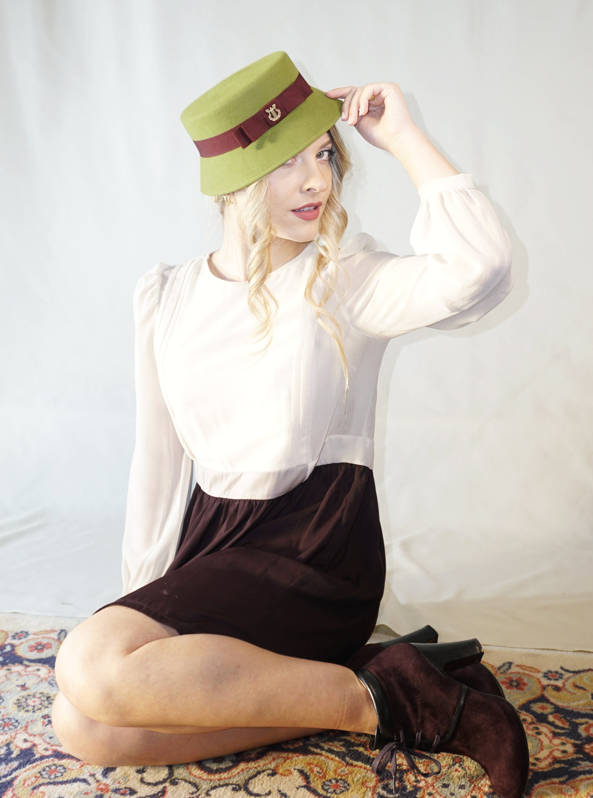 Aristocratic Melody lime pillbox felt hat with double burgundy bow and 14ct gold-plated silver lyre by Anna Xaniotaki - front angle view