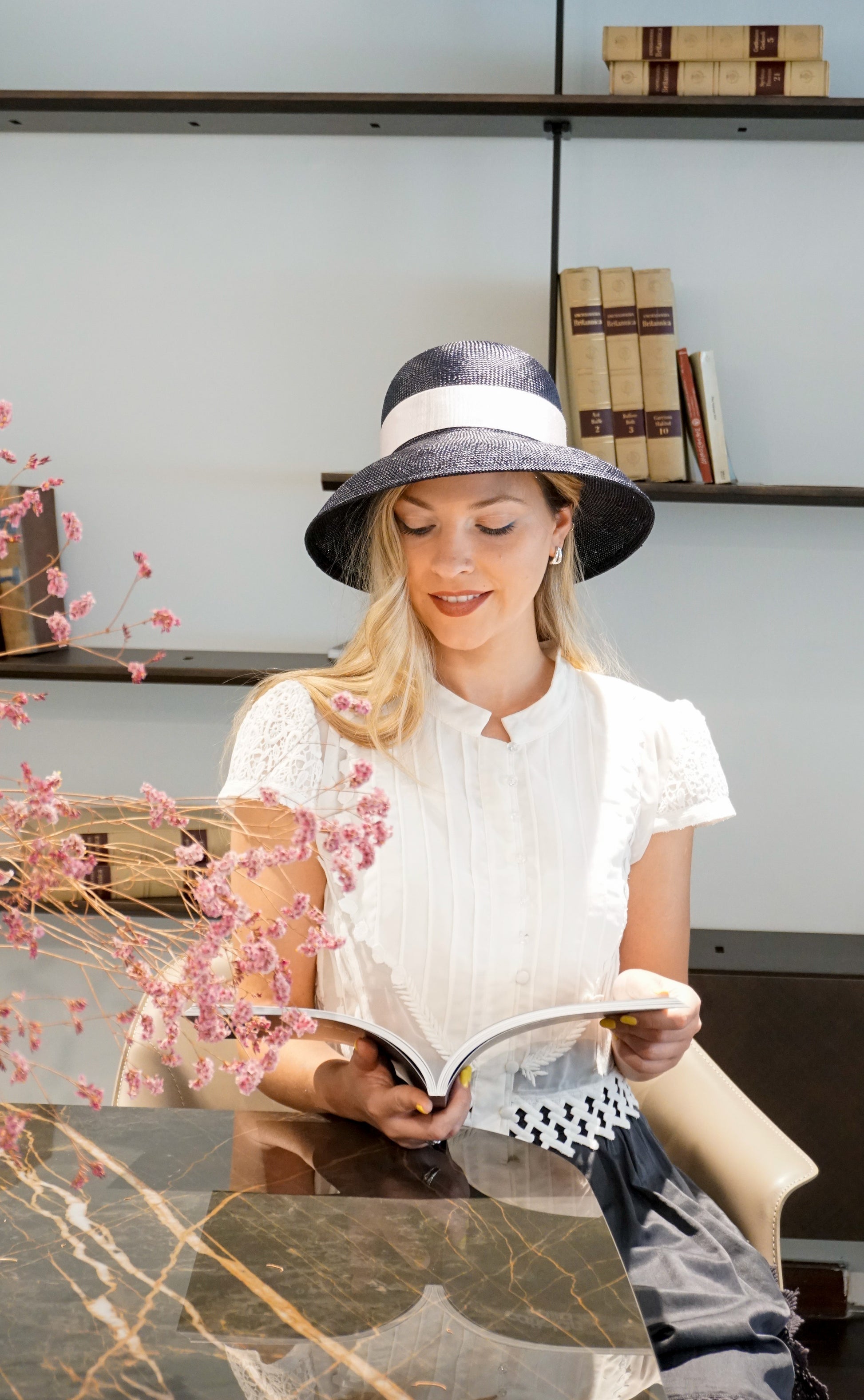 Isioni Ode navy blue viscose straw hat with pink double bow and sterling silver lyre by Anna Xaniotaki -  front left three-quarter view