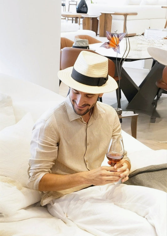 Man wearing the André fedora straw hat in ivory with black Italian cotton grosgrain band and bow, front view. Custom made-to-order fedora for summer special occasions, garden parties, vacations or for everyday man's elegance. Bespoke couture millinery by Anna Xaniotaki