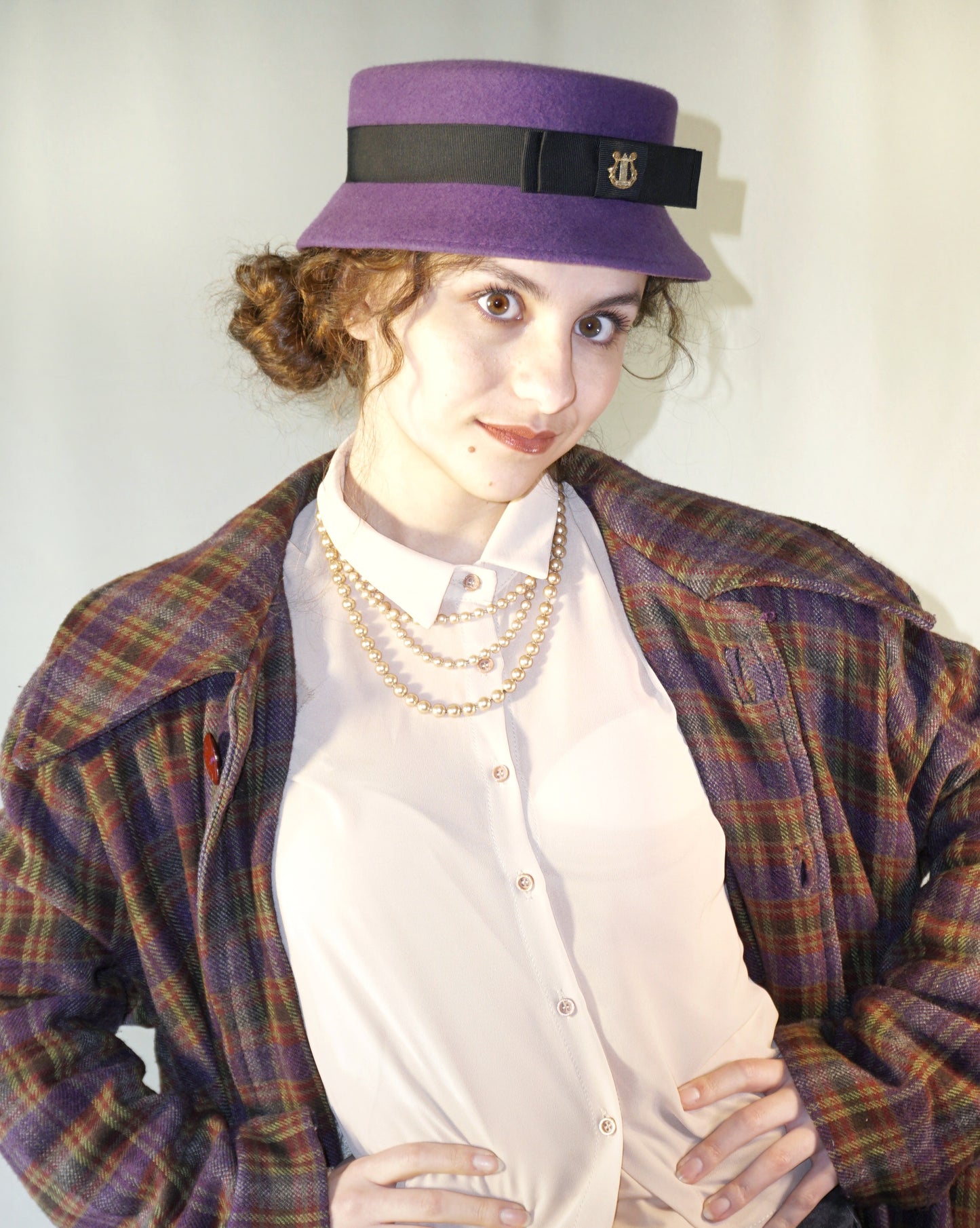 
Aristocratic Melody Pillbox Hat in Royal Purple Wool Felt with Black Double Bow and Gold Lyre by Anna Xaniotaki - three-quarter front right view