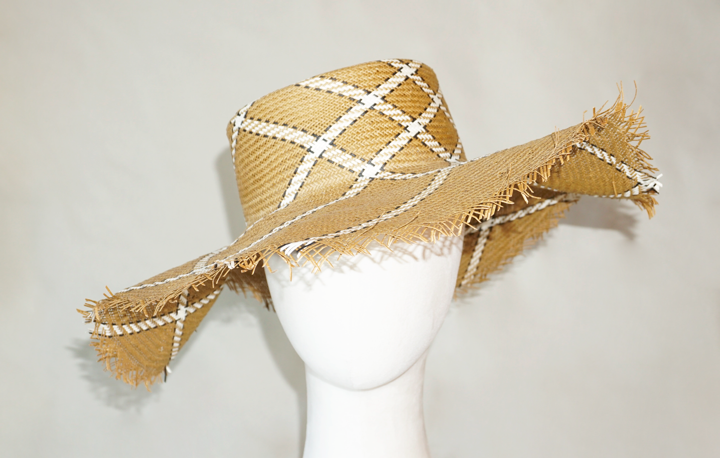 Aura hand-woven wide brim hat, golden chestnut Toyo paper straw, ivory & black geometric plaid, bohemian sculptural presence, close-up front view by Anna Xaniotaki