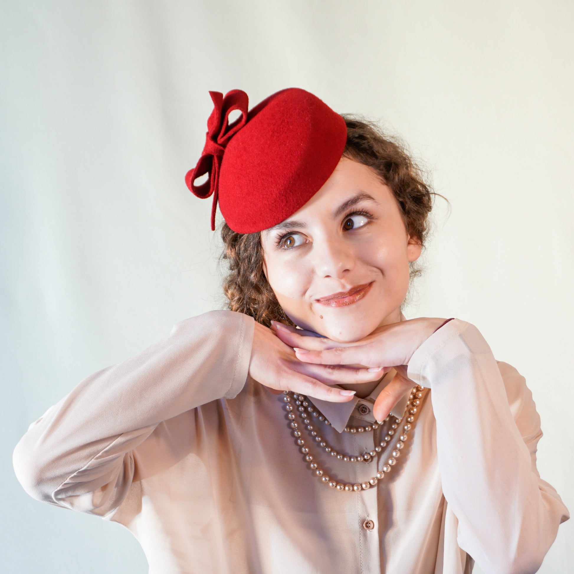 Erato Ode red felt pillbox hat with handmade felt bow and 14ct gold-plated silver lyre by Anna Xaniotaki - front view