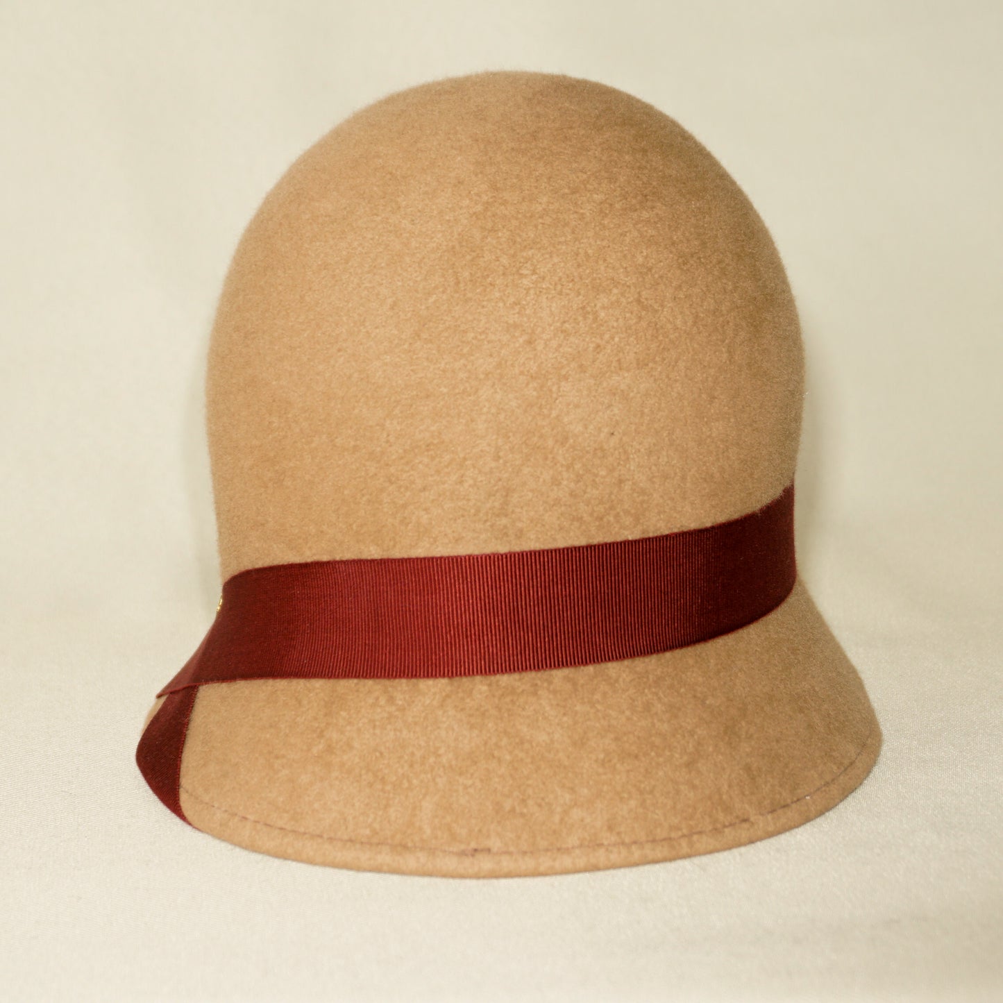 Daize cloche hat in camel wool felt with red ribbon and gold lyre by Anna Xaniotaki - front view