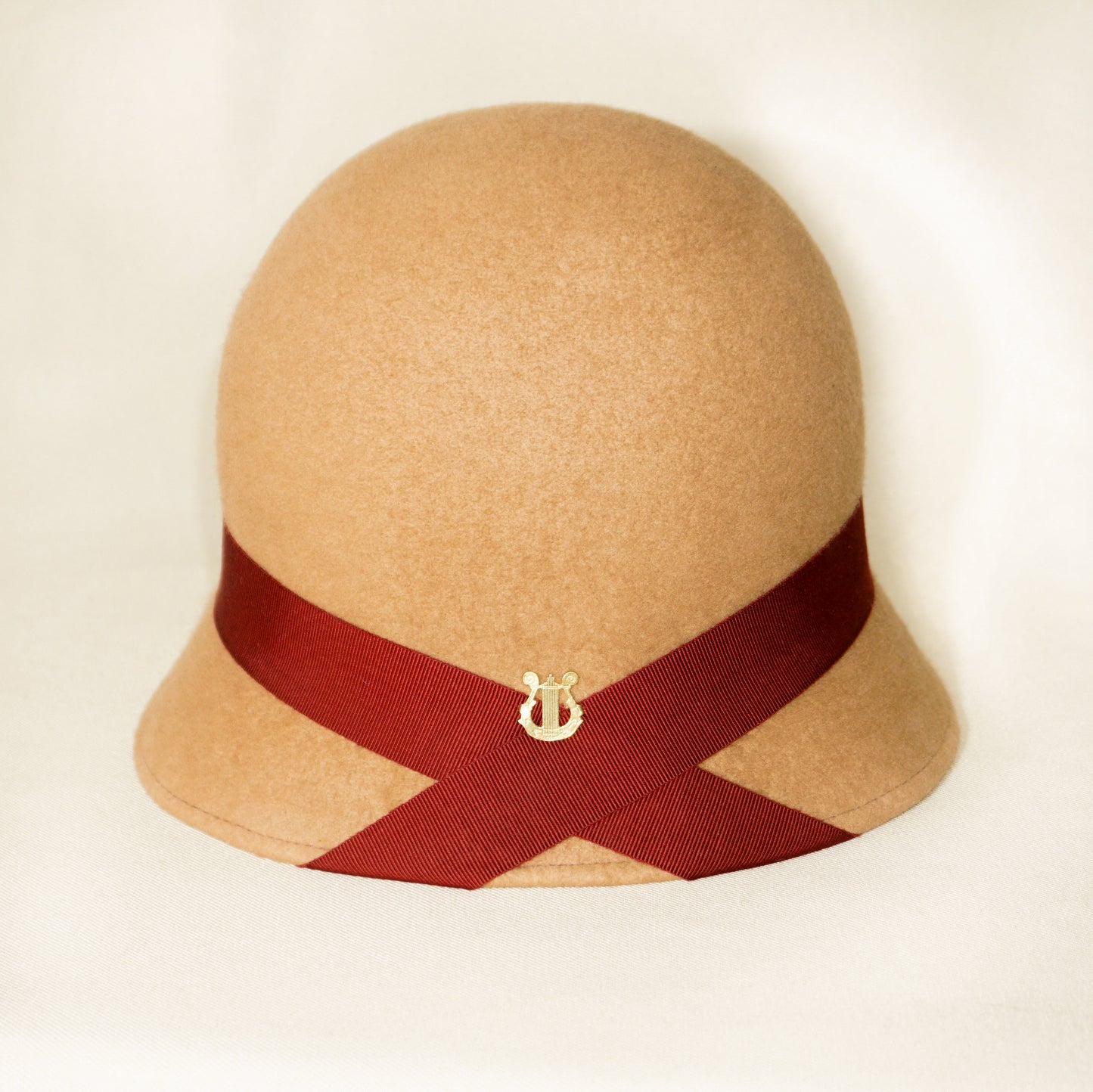 Close-up of 14-carat gold plated lyre on Daize cloche hat by Anna Xaniotaki