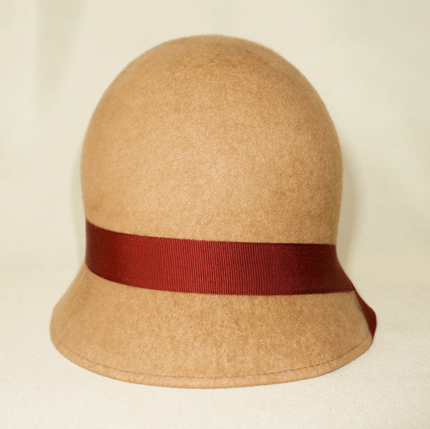 Daize cloche hat in camel wool felt with red ribbon and gold lyre by Anna Xaniotaki - front view