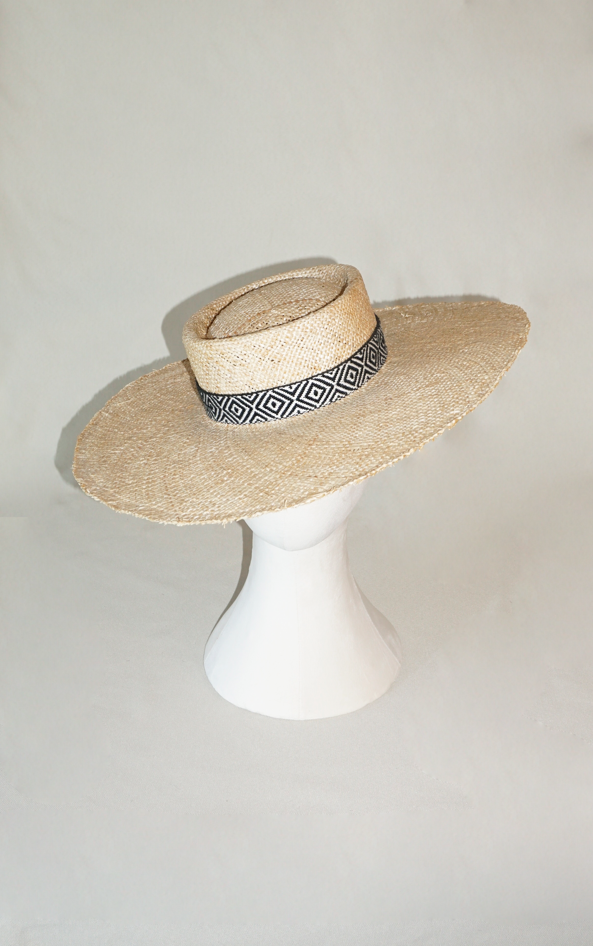 Delos handmade wide brim boater hat, pork pie crown, natural raffia straw, woven black & ivory geometric band with back bow, front & top view by Anna Xaniotaki 
