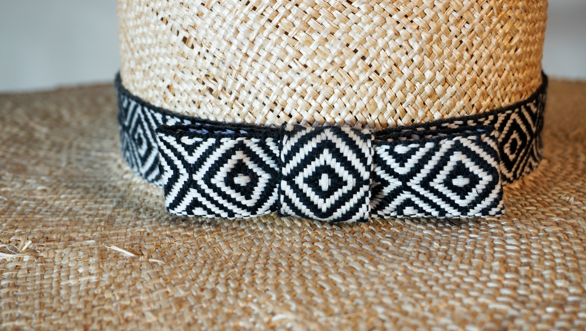 Delos handmade wide brim boater hat, pork pie crown, natural raffia straw,  woven black & ivory geometric band with back bow, close back view by Anna Xaniotaki 