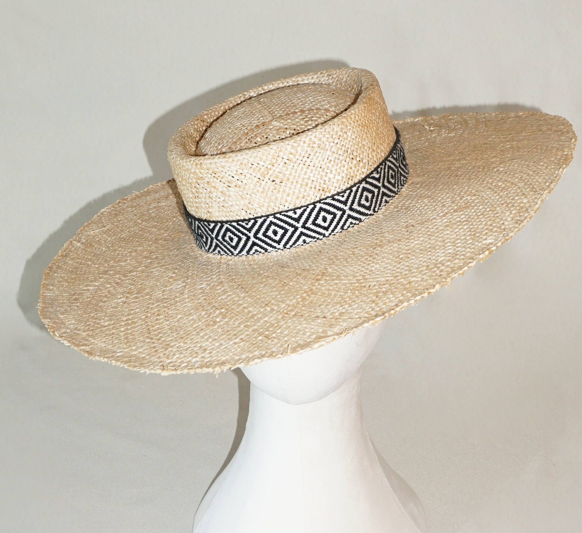 Delos handmade wide brim boater hat, pork pie crown, natural raffia straw,  woven black & ivory geometric band with back bow, front & top view by Anna Xaniotaki 
