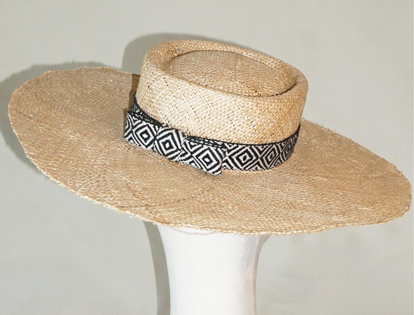 Delos handmade wide brim boater hat, pork pie crown, natural raffia straw,  woven black & ivory geometric band with back bow, back view by Anna Xaniotaki 