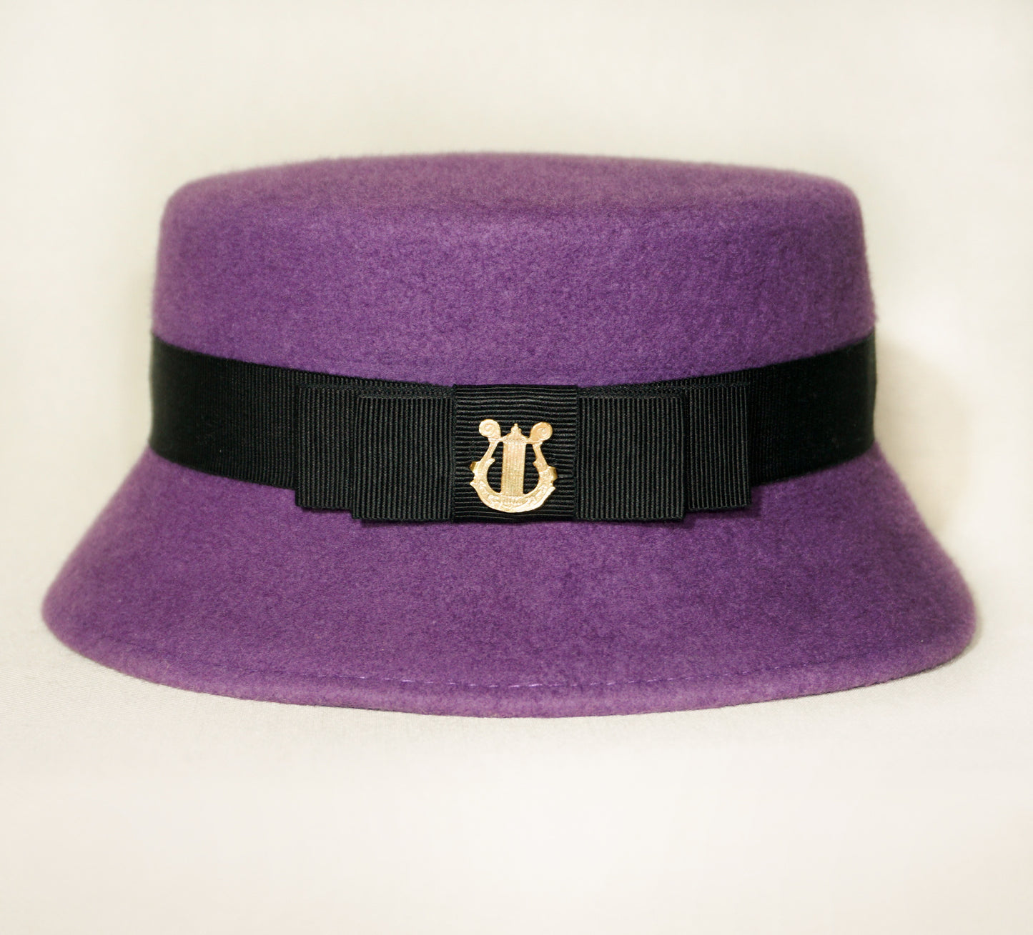 Aristocratic Melody Pillbox Hat in Royal Purple Wool Felt with Black Double Bow and Gold Lyre by Anna Xaniotaki - bow detail, front view