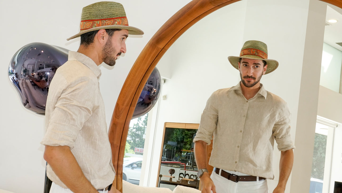 Man wearing the Indy Safari Fedora Hat in olive green paper straw with coral Italian cotton grosgrain ribbon and woven orange, coral and green band, rght side view and mirror front view. Custom made-to-order fedora for summer special occasions, garden parties, vacations or for everyday man's elegance. Bespoke couture millinery by Anna Xaniotaki.
