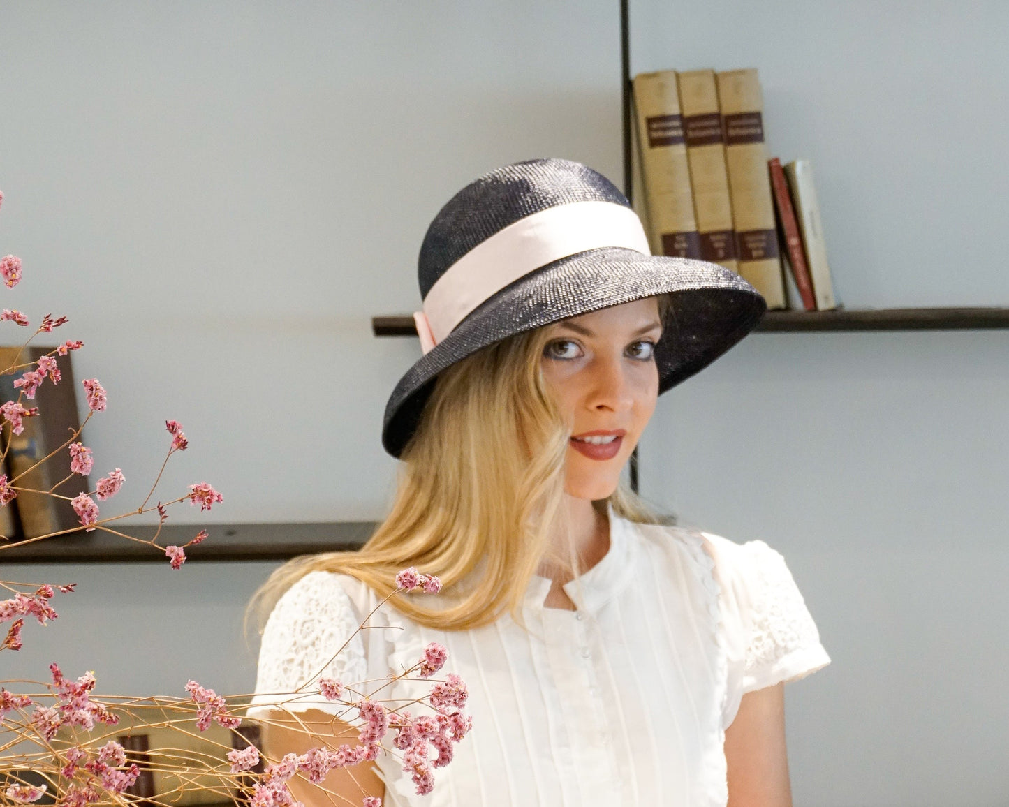 Isioni Hat in navy blue visca straw with pink Italian cotton grosgrain band, double bow and 925 sterling silver lyre by Anna Xaniotaki - front right three-quarter view