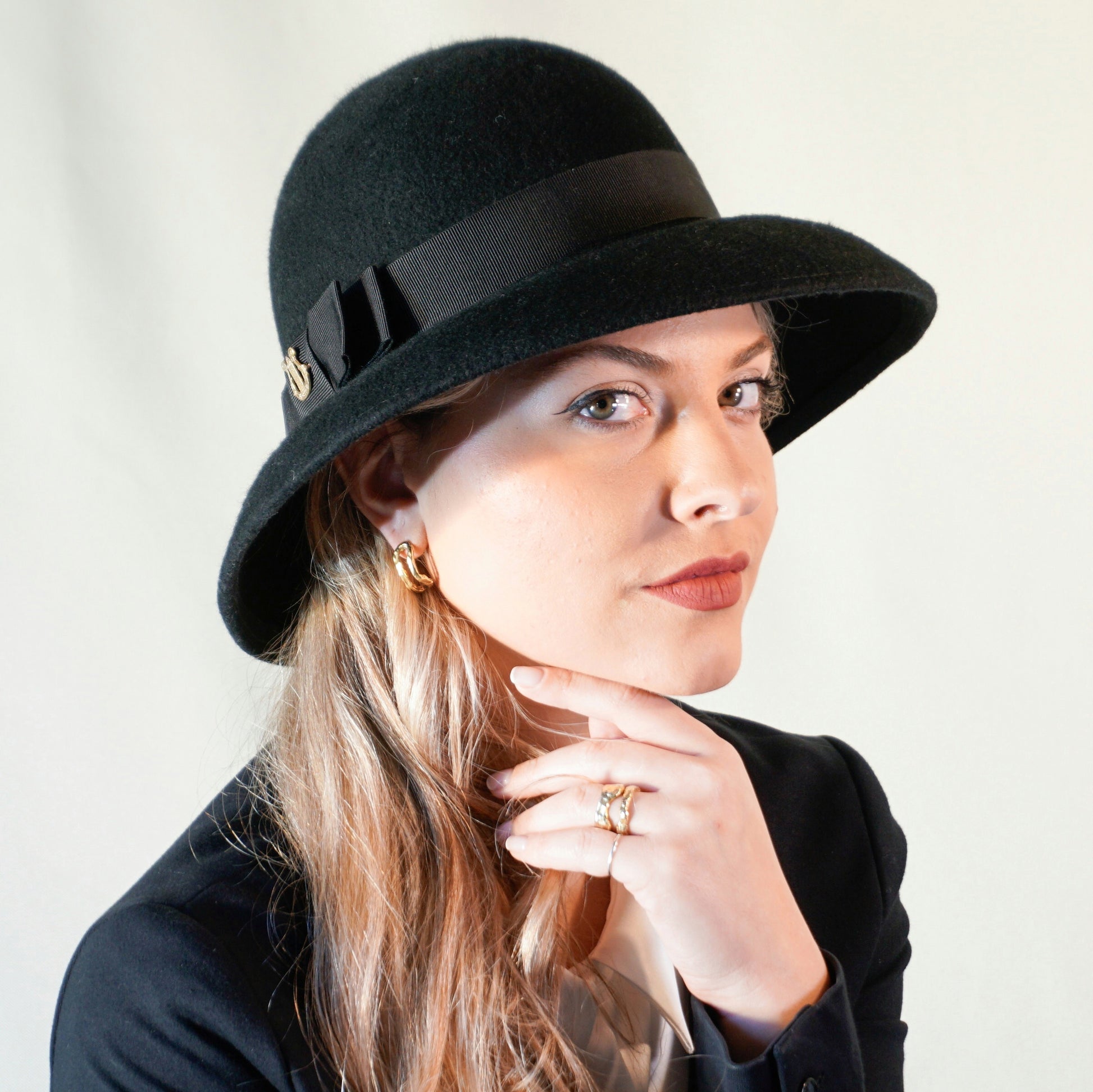 Noir Elegance Hat in Wool Felt with Bow and Gold Lyre by Anna Xaniotaki - three-quarter front right view
