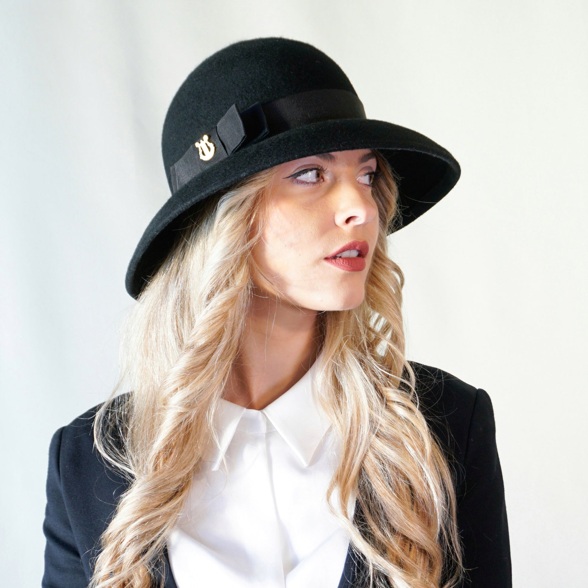 Noir Elegance Hat in Wool Felt with Bow and Gold Lyre by Anna Xaniotaki - three-quarter front right view