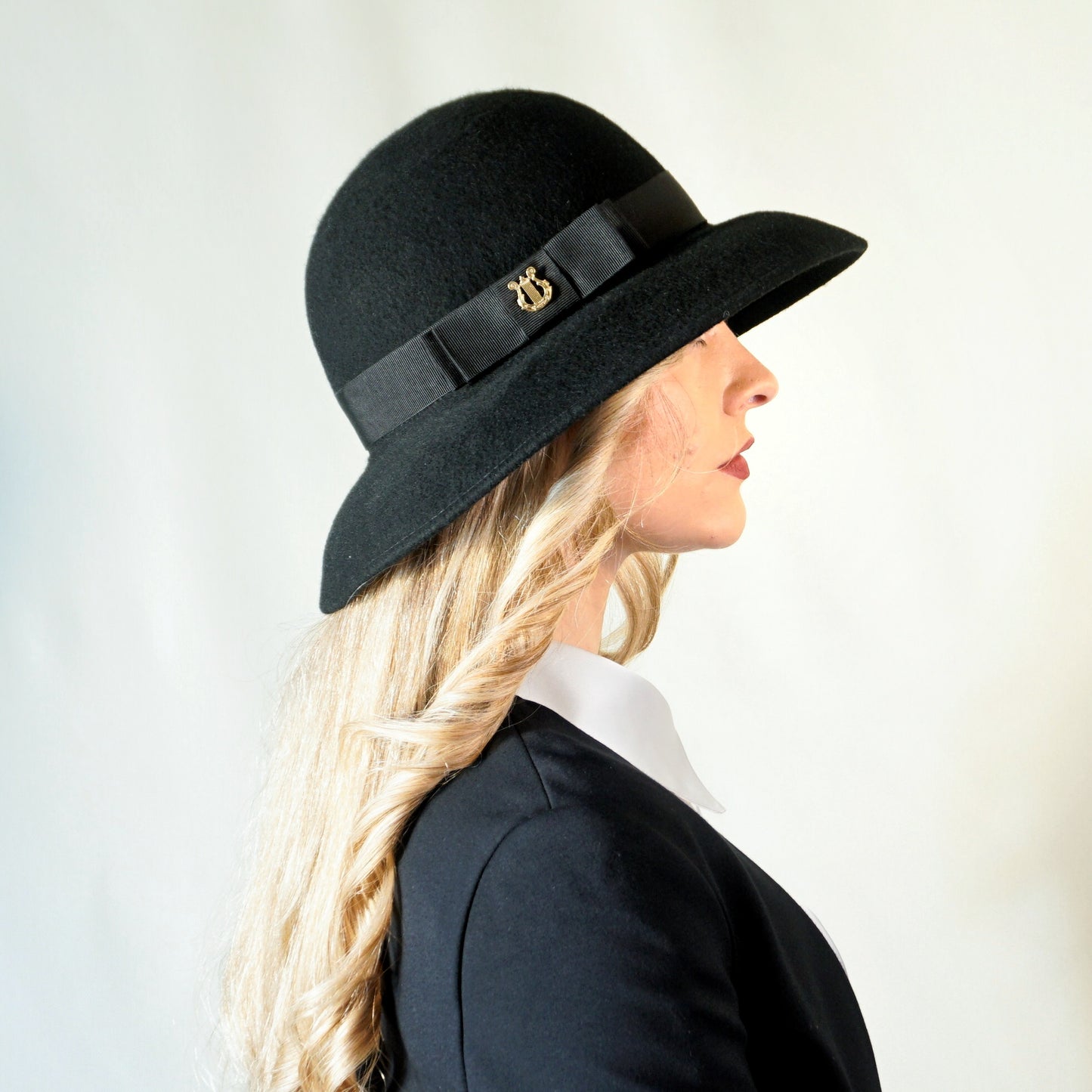 Noir Elegance Hat in Wool Felt with Bow and Gold Lyre by Anna Xaniotaki - bow detail, three-quarter front left view