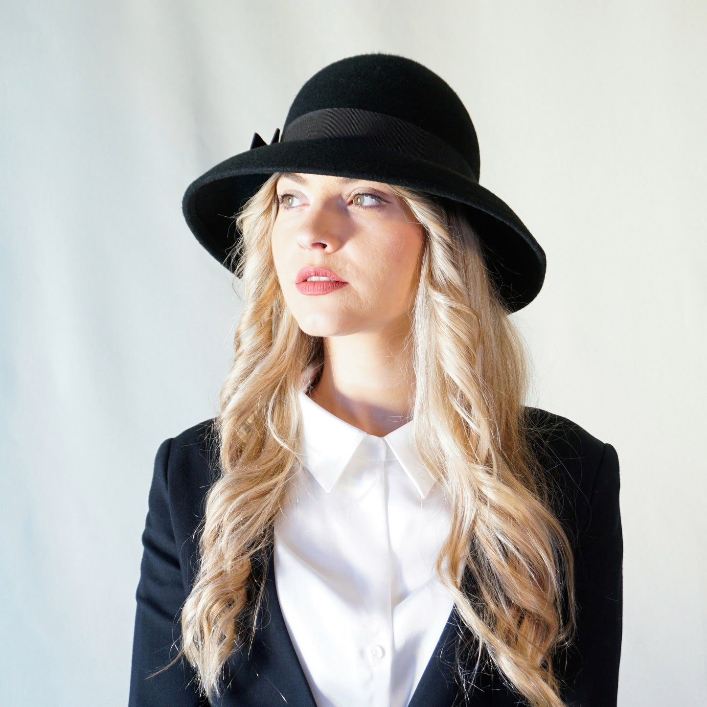 Noir Elegance Hat in Wool Felt with Bow and Gold Lyre by Anna Xaniotaki - three-quarter front left view