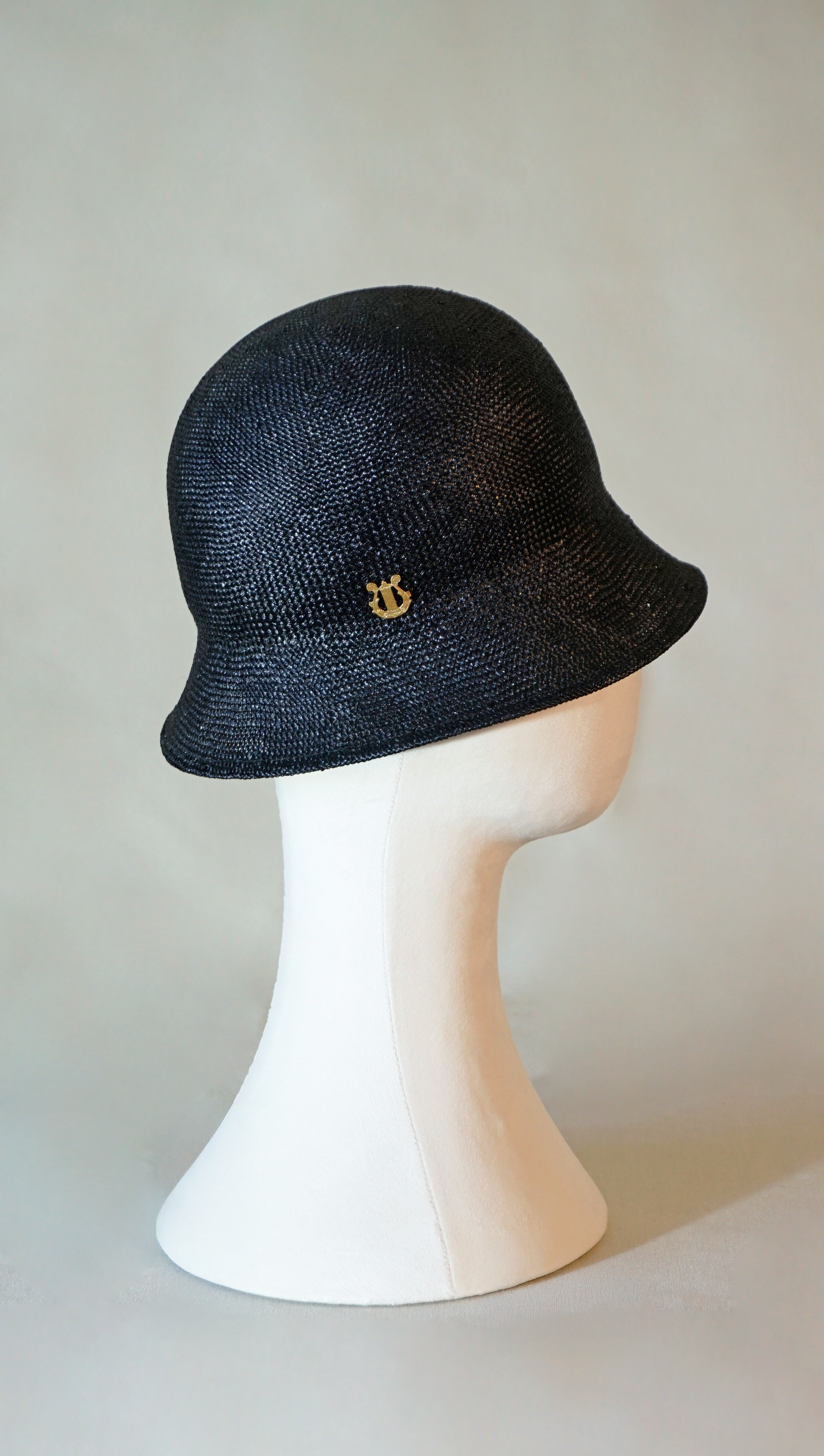 Nyx Cloche Hat in Visca Straw in Black with a Gold Lyre by Anna Xaniotaki, right side view