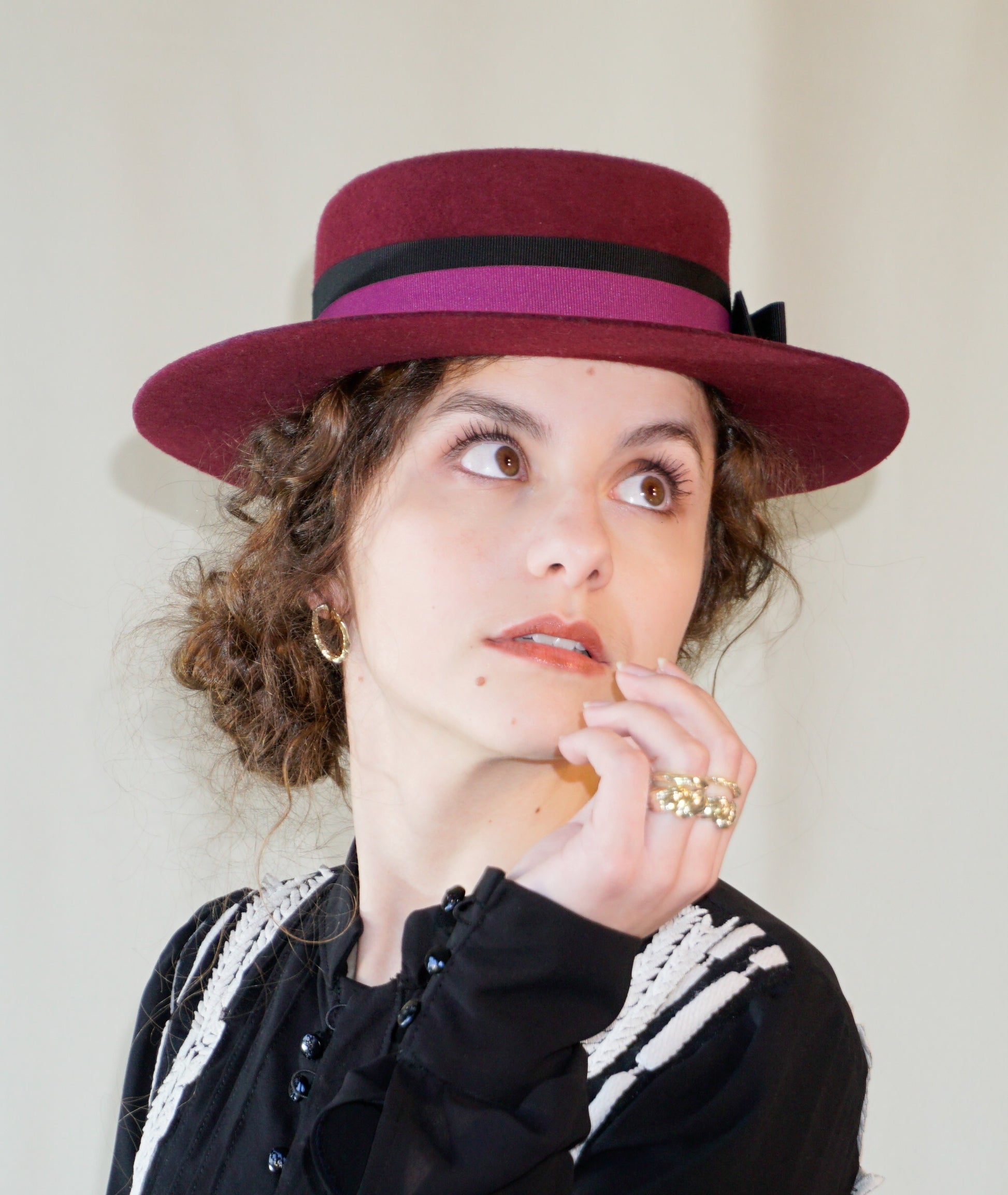 Right angle front view - woman wearing Scarlet Ode burgundy boater hat by Anna Xaniotaki