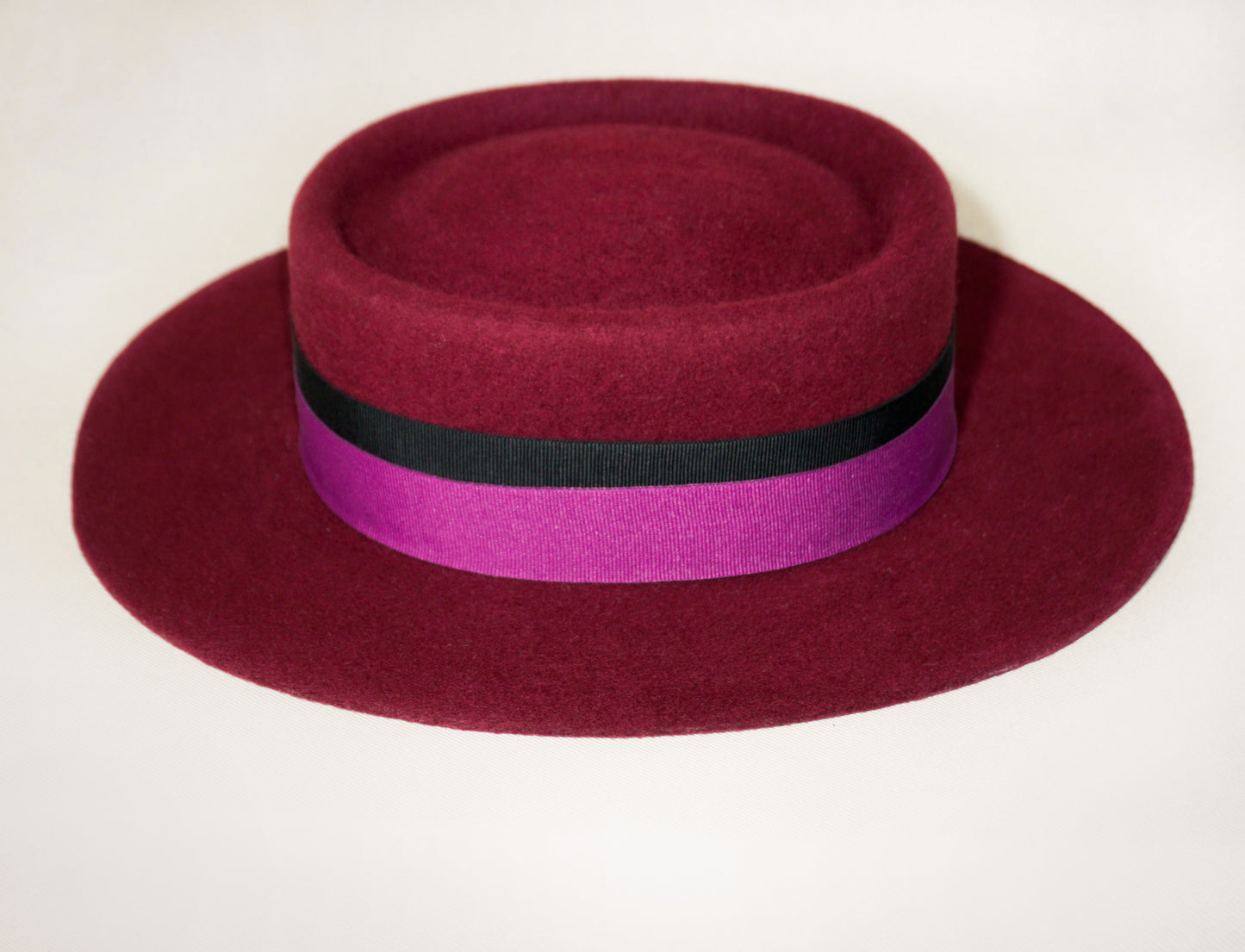 Left side view of Scarlet Ode burgundy boater hat by Anna Xaniotaki