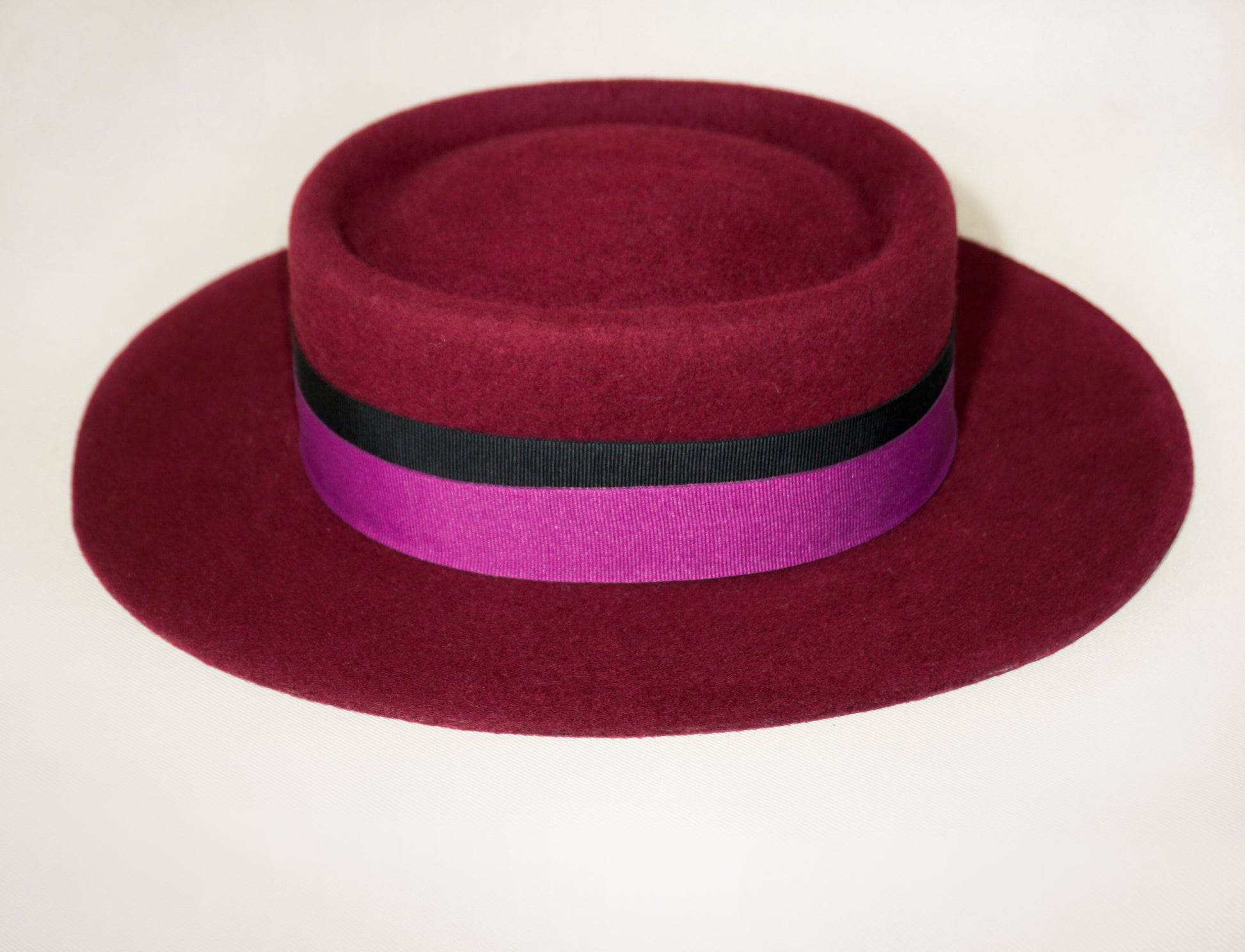 Left side view of Scarlet Ode burgundy boater hat by Anna Xaniotaki