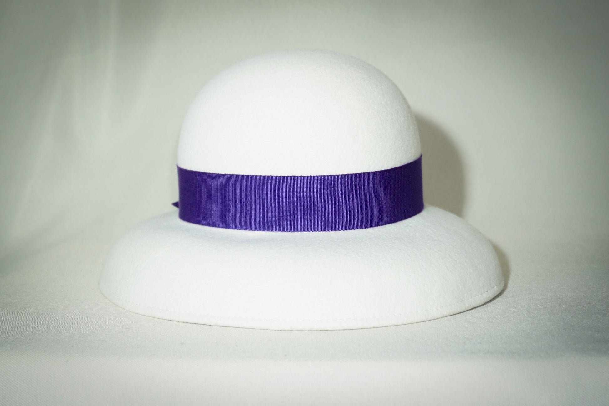 Blanche Élégance white felt hat with purple grosgrain bow and golden lyre by Anna Xaniotaki, back view