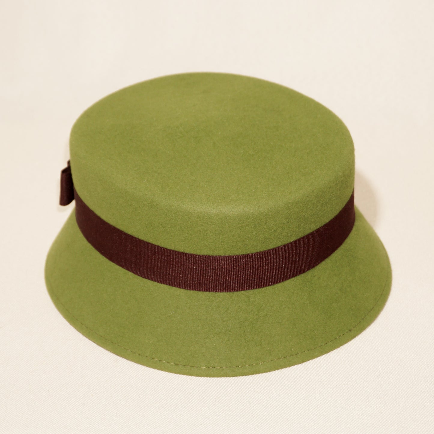 Aristocratic Melody lime pillbox felt hat with double burgundy bow and 14ct gold-plated silver lyre by Anna Xaniotaki, back angle view