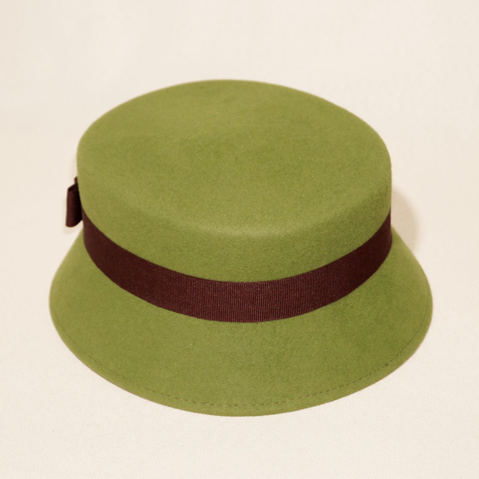 Aristocratic Melody lime pillbox felt hat with double burgundy bow and 14ct gold-plated silver lyre by Anna Xaniotaki, back angle view
